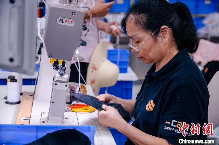 圖為員工在生產(chǎn)線工作?！±钅宪?攝