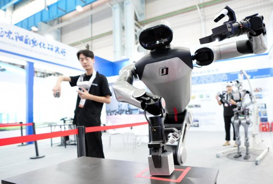9月5日，在沈陽的2025全球工業(yè)互聯(lián)網(wǎng)大會的展覽區(qū)現(xiàn)場，中國科學院沈陽自動化研究所的機器人工程師在調(diào)試具身智能操作系統(tǒng)。新華社記者 李鋼 攝